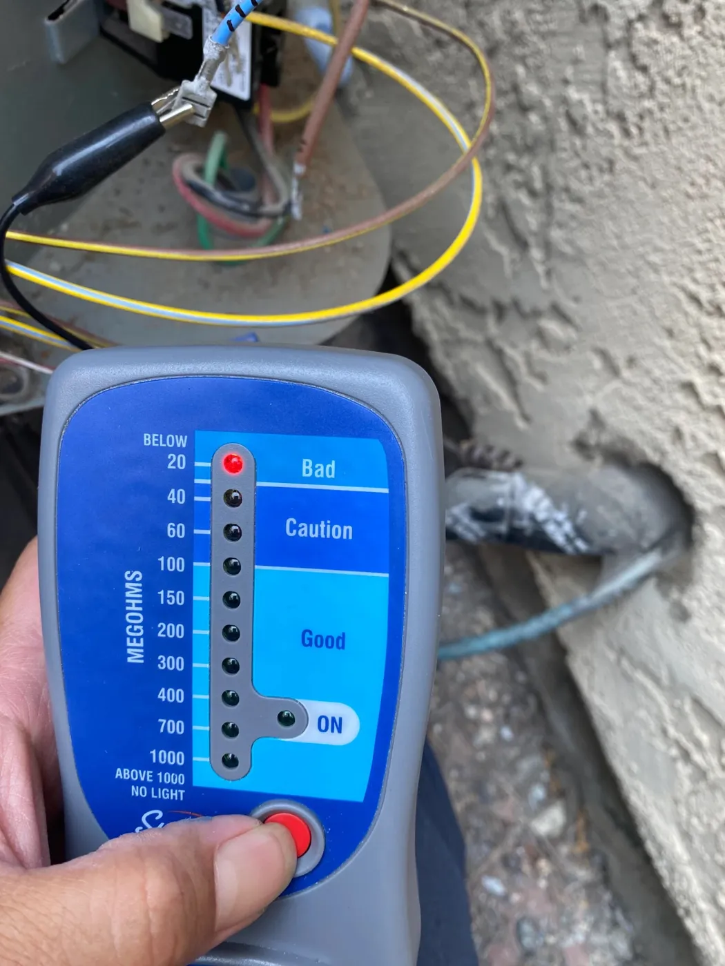 CrossBreeze tech running an insulation resistance test on an AC condenser in San Diego